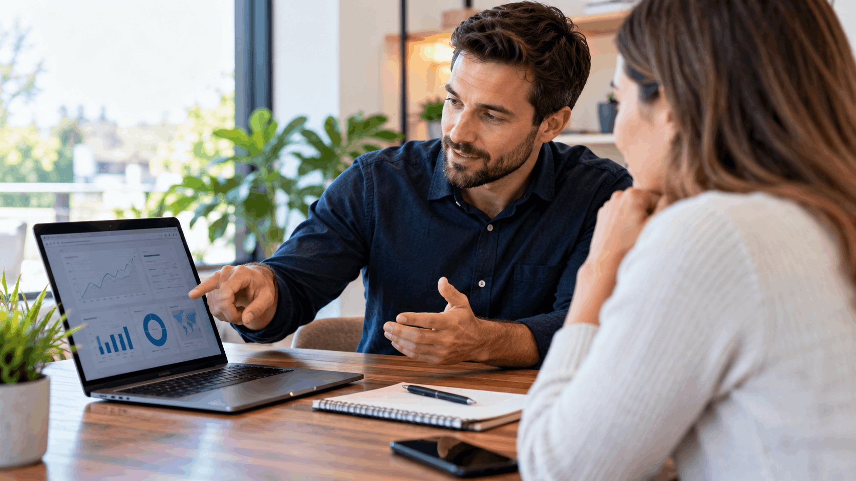 Business consultant explaining local SEO analytics dashboard on laptop to client in office