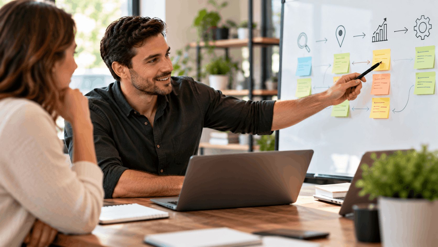 Two professionals collaborating on a digital marketing strategy whiteboard with sticky notes