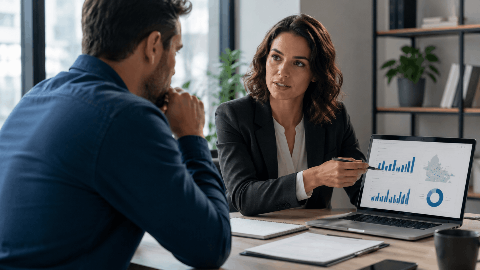 Business consultant presenting local SEO data charts and analytics on laptop to client