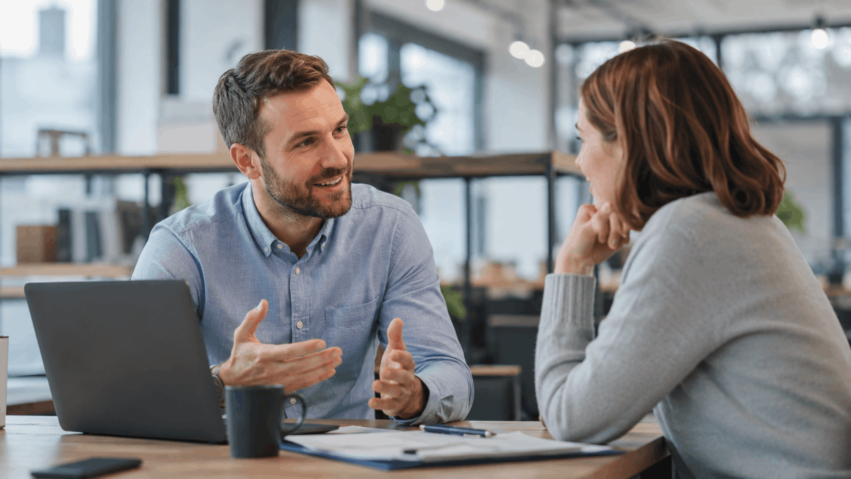 Business consultant discussing custom website strategy with client in modern office setting