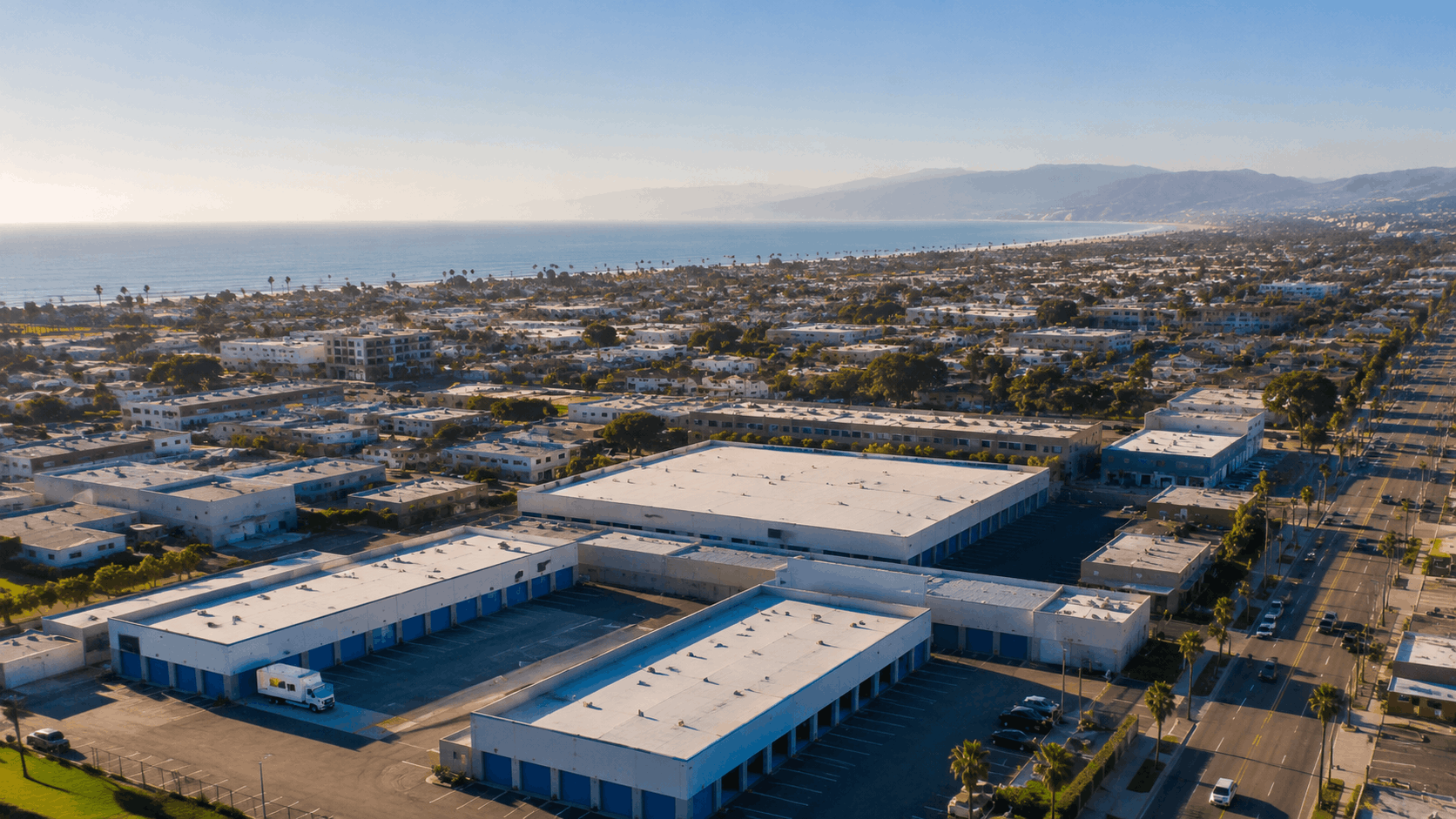 Aerial view of Los Angeles coastal storage facility with blue doors near ocean