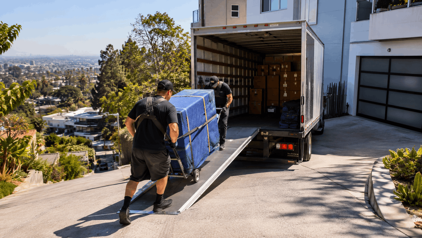 Two movers unloading furniture up a ramp in Hollywood Hills steep driveway