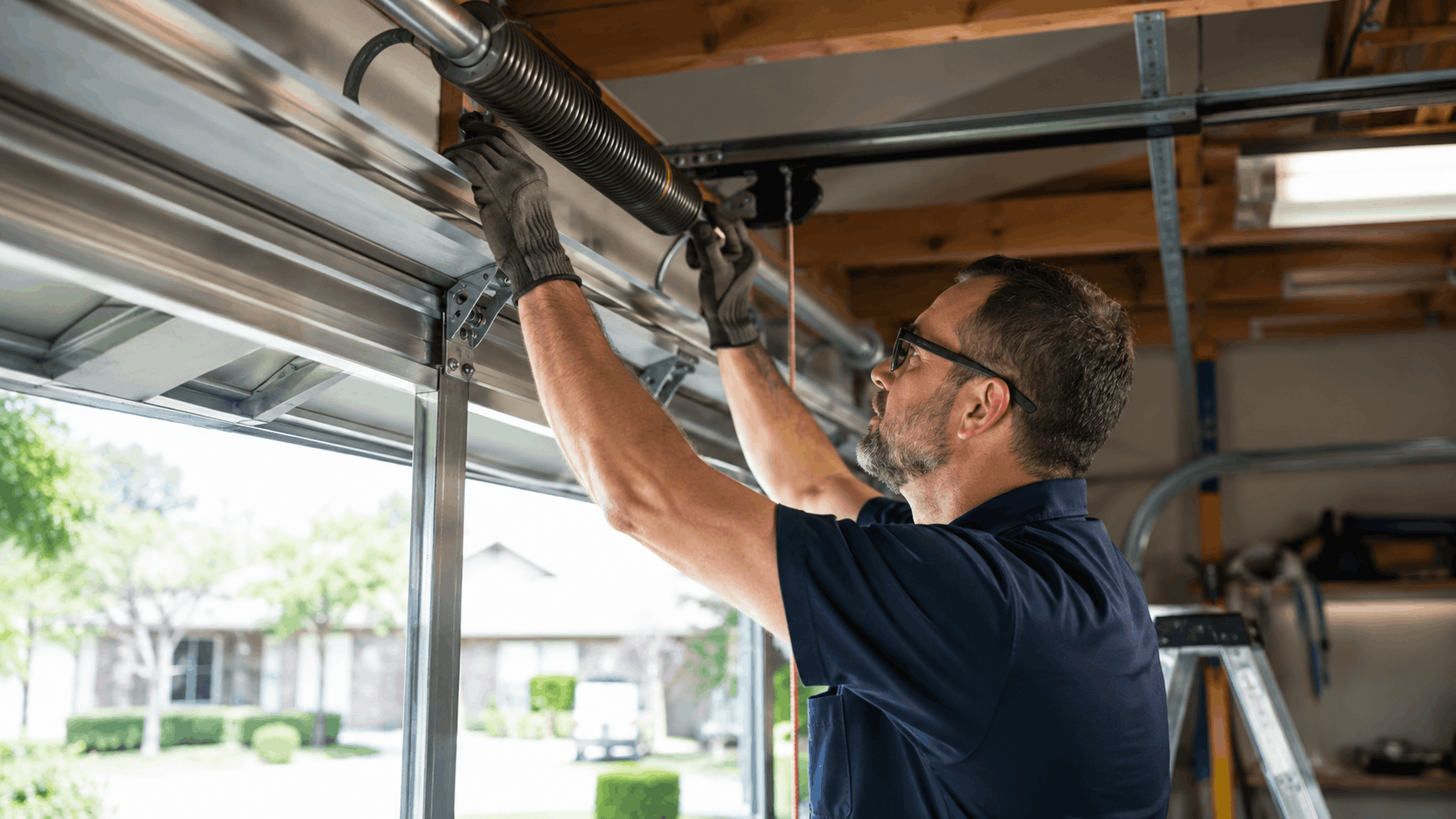 Garage door technician replacing torsion spring on overhead door track in Irvine