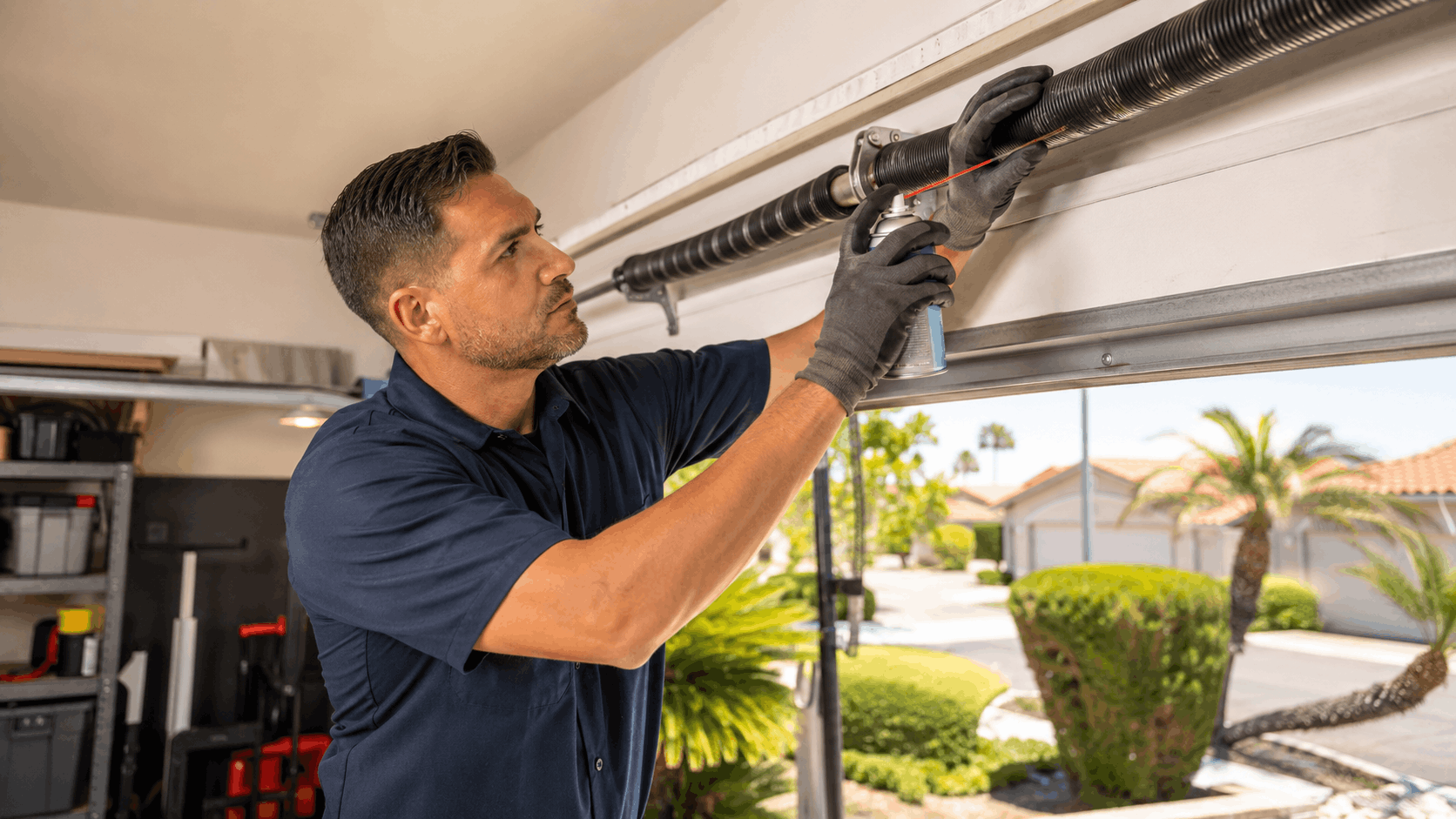Garage door technician lubricating torsion spring with spray can in Irvine home