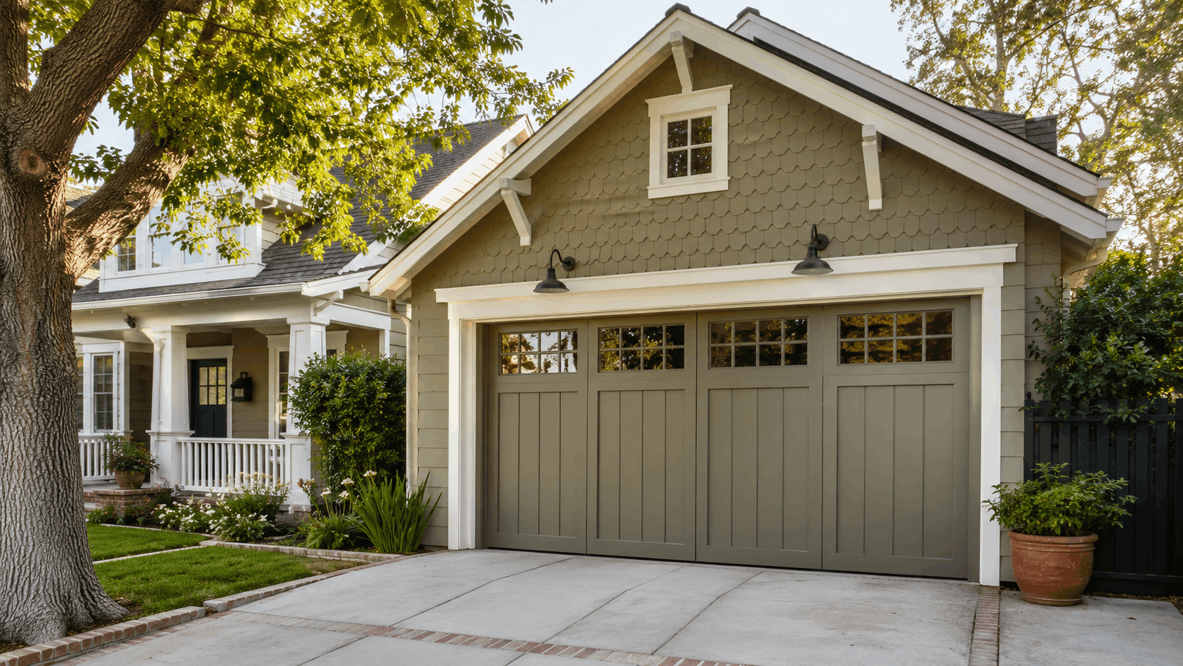 Craftsman-style home with historic-looking sage green garage door and decorative windows