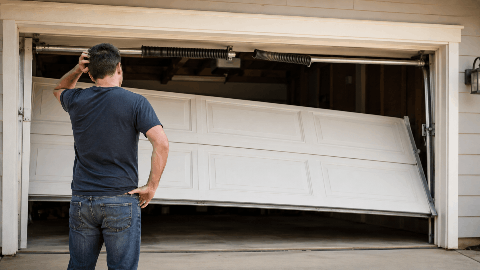 Confused Irvine homeowner inspecting broken malfunctioning garage door off tracks