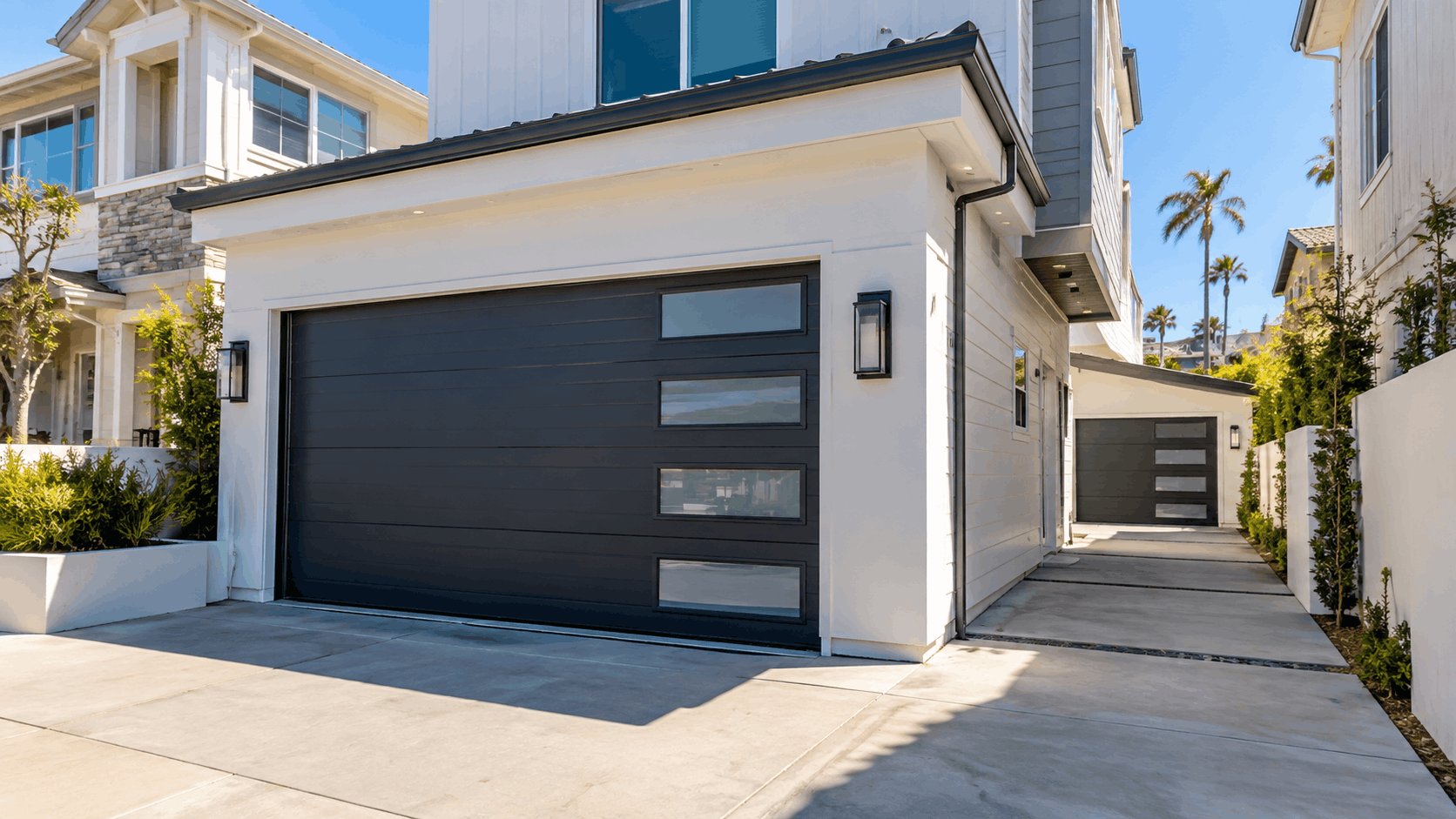Modern dark charcoal garage door with glass panels on coastal California home