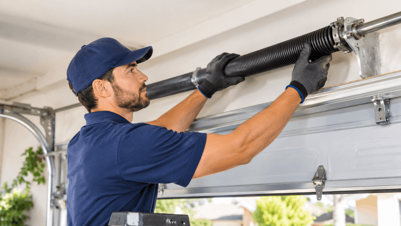 Technician replacing garage door torsion spring in Santa Ana Heights Irvine home